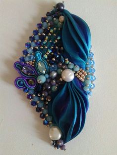 a close up of a brooch with pearls and beads on it's side