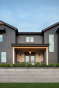 a large gray house sitting on top of a lush green field