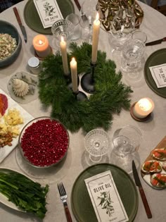 the table is set with candles, plates and food