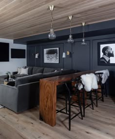 a living room filled with furniture next to a wooden table and two pictures on the wall