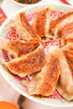 some dumplings are on a plate with dipping sauce