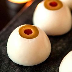 some white and brown beads are sitting on a black surface with candles in the background