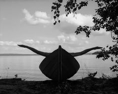 black and white photograph of a woman leaning on a boat