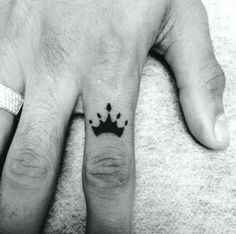 a hand with a crown tattoo on it