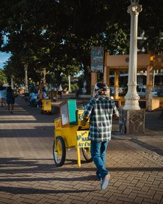 a man is walking down the street with a cart