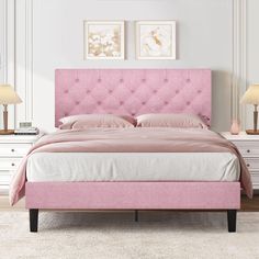 a pink bed in a white bedroom with two lamps on either side and one nightstand next to it