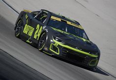 a race car driving around a track on a sunny day