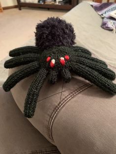 a knitted spider head on the back of a couch