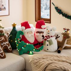 a group of stuffed animals sitting on top of a couch next to christmas trees and decorations