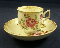 an antique tea cup and saucer decorated with flowers