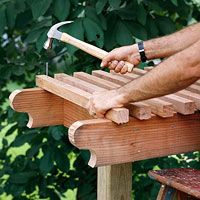 a man is holding an hammer over a piece of wood on top of a bench