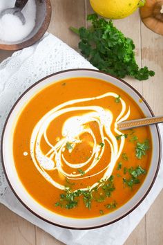 a bowl of carrot soup with parsley on top