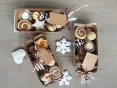 two boxes filled with different types of cookies and pastries on top of a wooden floor