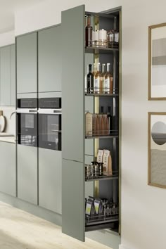 an open cabinet in the middle of a kitchen with lots of bottles and spices on it