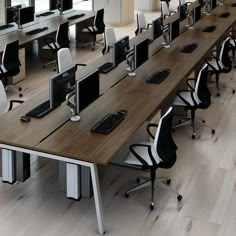 there are many computer screens on the desks in this office space, all lined up