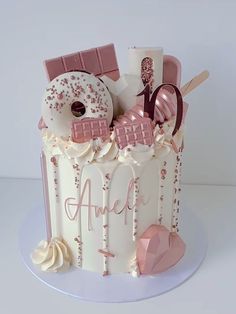 a white cake with pink frosting and decorations