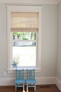 two blue chairs sitting in front of a window