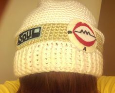 a woman wearing a white knitted hat with patches on the front and back of her head