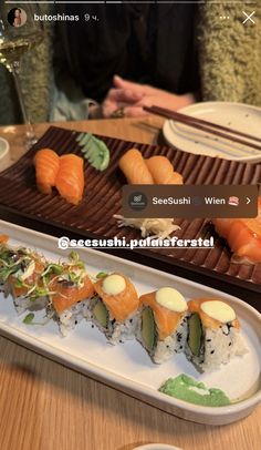 sushi is served on a plate with chopsticks in front of the plates