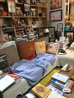 a room filled with lots of books and pictures on the wall next to a bed