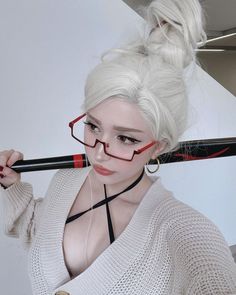 a woman with white hair and glasses holding a black umbrella