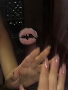 two hands reaching out towards each other in front of a mirror with pink lipstick on it