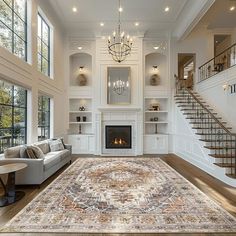 a large living room with white walls and wood flooring on the floors, along with a fireplace