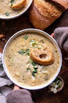 two bowls of soup with bread on the side