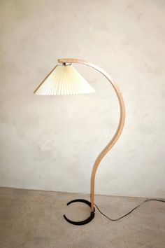 a lamp that is sitting on top of a wooden stand next to a white wall