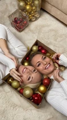 two women laying on the floor with christmas decorations