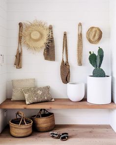 a shelf with baskets, hats and other items hanging on the wall next to it