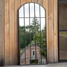 an arched window is shown in front of a wooden building