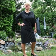 a woman in a black dress is posing for the camera