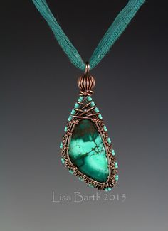 a necklace with a green stone in the center and turquoise beads on it's sides