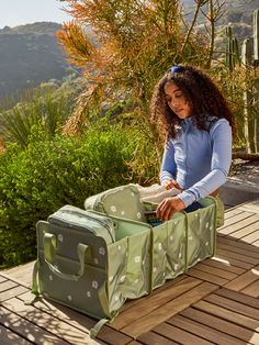 a woman is packing her suitcase on the deck