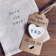 save the date tags are sitting next to each other on top of a wooden table