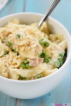 a white bowl filled with pasta and peas