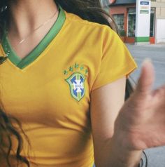 a woman in a yellow shirt is holding her hand out