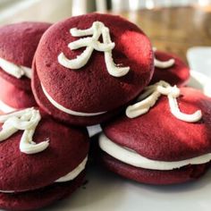 red velvet cookies with white frosting are stacked on top of each other in the shape of letters