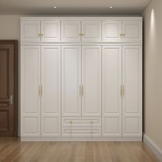 an empty room with white cupboards and wood flooring is seen in this image