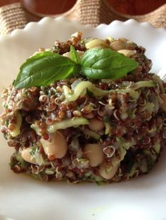 a white plate topped with pasta and greens