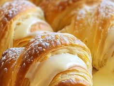 croissants with white icing and powdered sugar sitting on top of each other