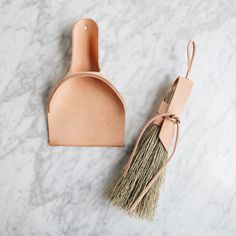 a leather brush and holder on a marble surface