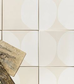 a close up of a tile wall with a piece of paper on top of it