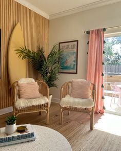 a living room with two chairs and a surfboard on the wall