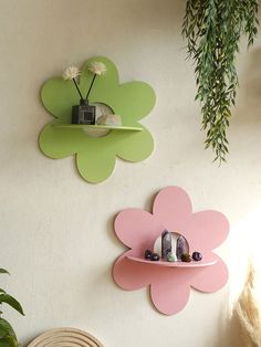 two flower shaped shelves are hanging on the wall next to a potted plant and small bird figurines