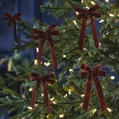 christmas trees with red bows and lights on them