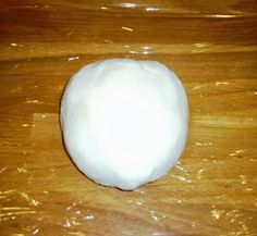 a white ball of cotton sitting on top of a wooden table next to a plastic bag