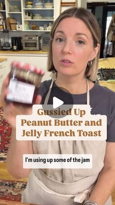 a woman in an apron holding up a jar of peanut butter and jelly french toast