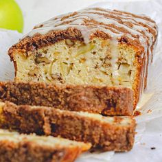 sliced loaf of cake sitting on top of a piece of paper next to an apple